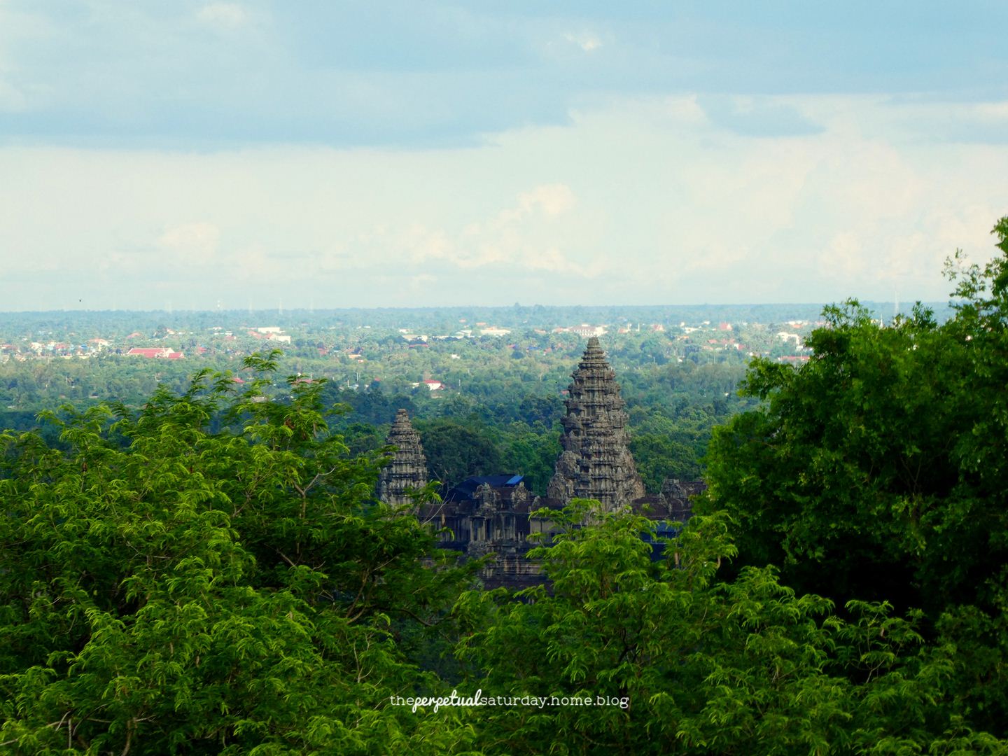 View of Angkor Wat from the top of Phnom Bakheng. It's obscured by trees.